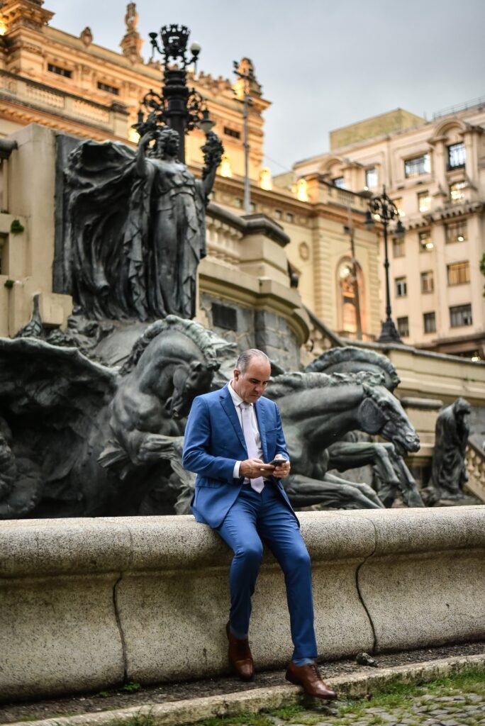 Gustavo Fernandes, advogado, em atendimento online pelo celular, com o Theatro Municipal de São Paulo ao fundo