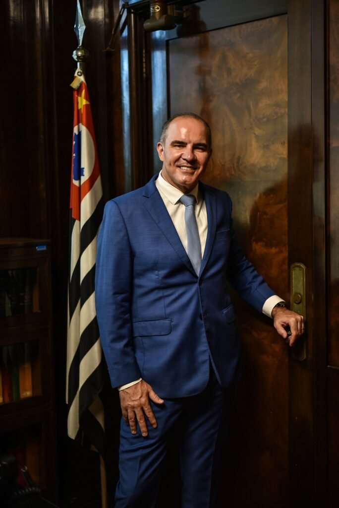 Gustavo Fernandes, advogado com atuação no interior de São Paulo, ao lado da bandeira do Estado de São Paulo