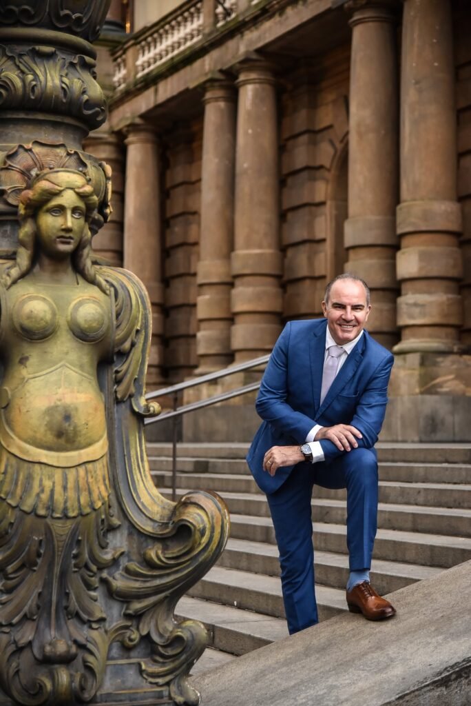 Gustavo Fernandes, advogado do consumidor, em postura acessível, próximo à escadaria do Theatro Municipal