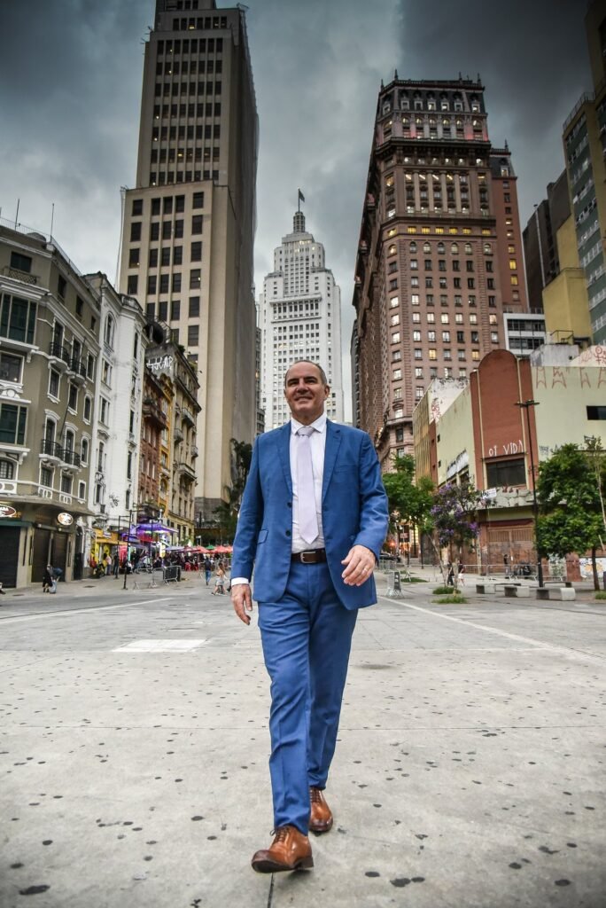 Gustavo Fernandes, advogado, caminhando no centro de São Paulo com o Edifício Altino Arantes ao fundo